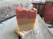 Soap bar with three stripes; bottom beige, middle rust and top rose colored with pomegranate seeds sprinkled on top
