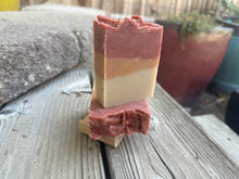 Soap bar with three stripes; bottom beige, middle rust and top rose colored with pomegranate seeds sprinkled on top