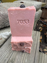 Pink soap Rosa Parks soap bar with “7053” stamped on the front. Topped with a rosehip.