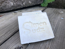 Off-white soap bar stamped with Simon Sudz on the front
