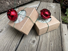 Snowflake shaped soap bars in gift boxes with a red bell