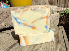 Off white soap bar with dark blue and orange swirls 