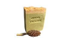Olive geeen soap with gold/yellow top. Stamped “Good Trouble”