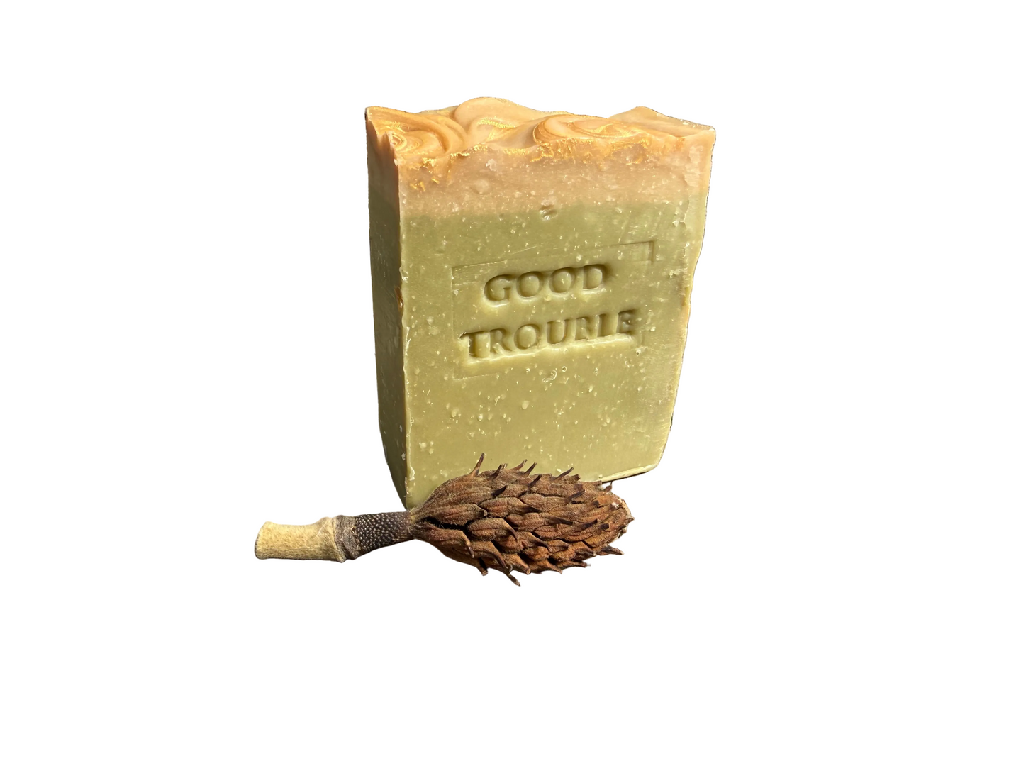 Olive geeen soap with gold/yellow top. Stamped “Good Trouble”