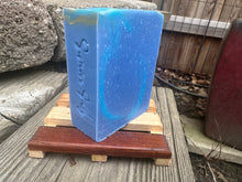 blue soap bars on a soap plank in a backyard with words simon sudz stamped onto the side