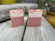 two handcrafted soap bars with pink and blue colors and soap rose charm