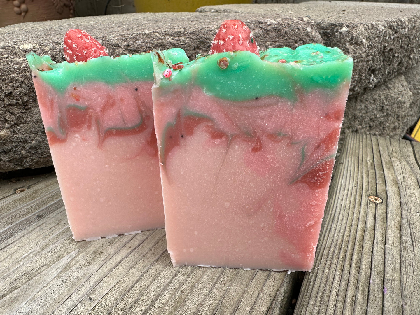 Pink soap bar with red and green swirls; soap strawberry embed on top.