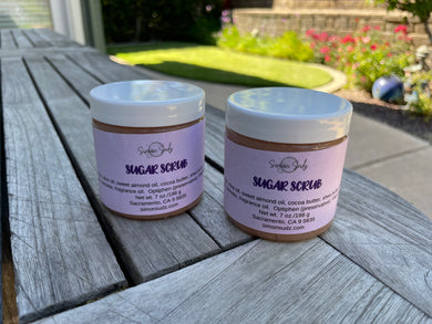 two round skincare jars with white caps and purple labels
