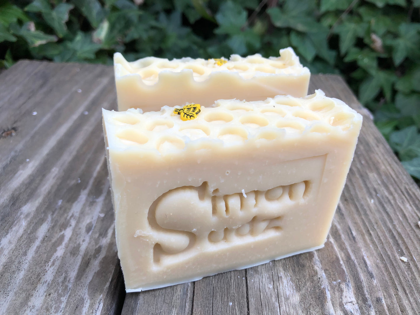 two beige honeycomb pattern soap bars with bee charm and stamped letters